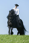 woman rides Friesian horse