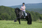 woman rides Friesian horse