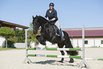 woman rides Friesian horse