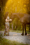 young woman with friesian mare