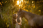 young woman with friesian mare