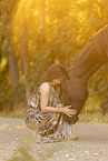 young woman with friesian mare