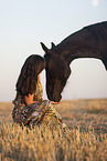 young woman with friesian mare