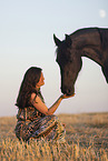 young woman with friesian mare