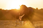 young woman with friesian mare