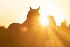 young woman with friesian mare