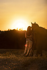 young woman with friesian mare