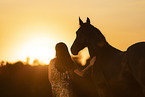 young woman with friesian mare