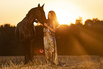 young woman with friesian mare