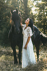 young woman in dress with frisian horse