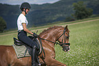 young woman rides German Riding Pony