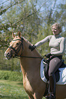 woman rides German Riding Pony