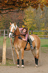 woman rides Haflinger horse
