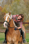 woman rides Haflinger horse