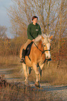 woman rides haflinger horse
