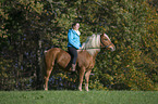 woman rides Haflinger horse