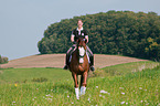 woman rides Hessian Warmblood