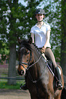 woman rides Holsteiner horse