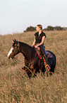 woman rides Paint Horse