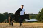 dog sitting on Shetland Pony