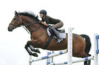 woman jumps with Trakehner