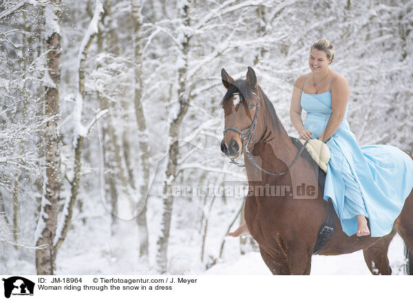 Woman riding through the snow in a dress / JM-18964