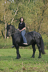 young woman with friesian horse