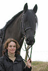 young woman with friesian horse
