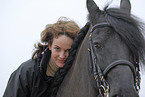 young woman with friesian horse