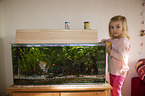 girl in front of an Aquarium with Swordtails and Angel Fish