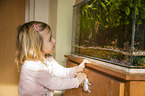 girl in front of an Aquarium with Swordtails and Angel Fish